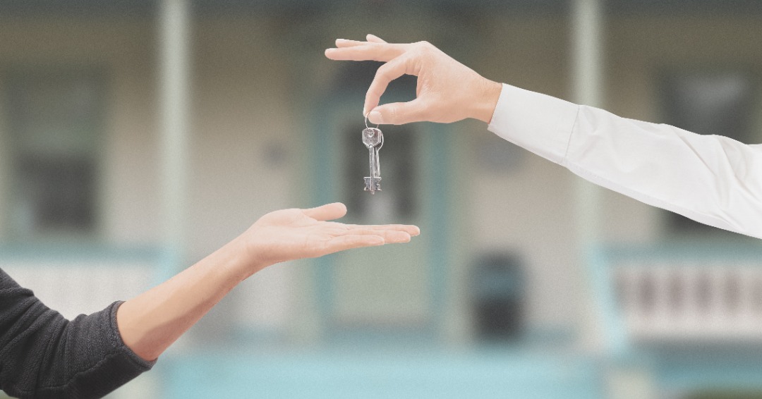 a home seller handing off the keys to a home buyer