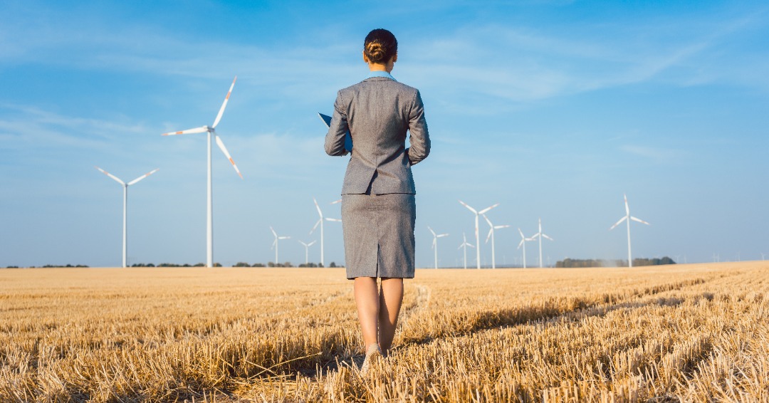 businesswoman standing in a wind farm