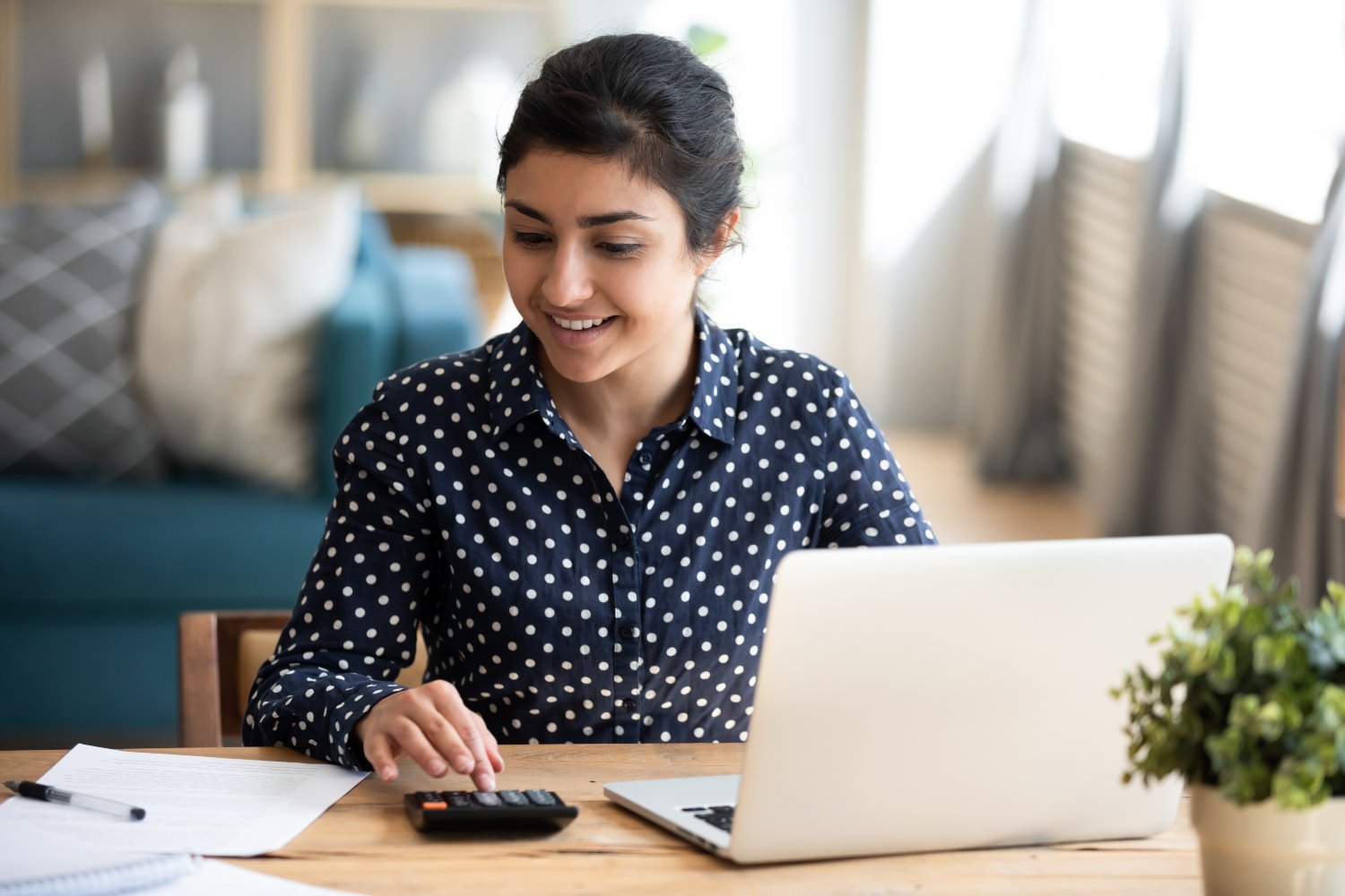 Young woman using computer and calculator to budget, plan – Birchwood FP